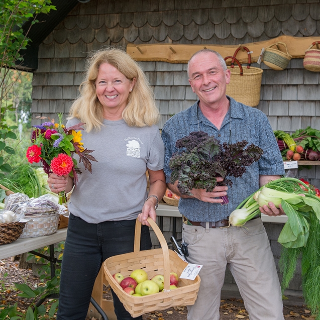 blond woman and man holding produce