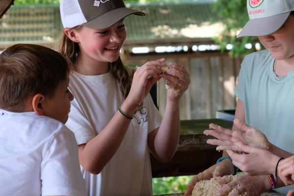 Children make dough in outdoor kitchen at Shelburne Farms